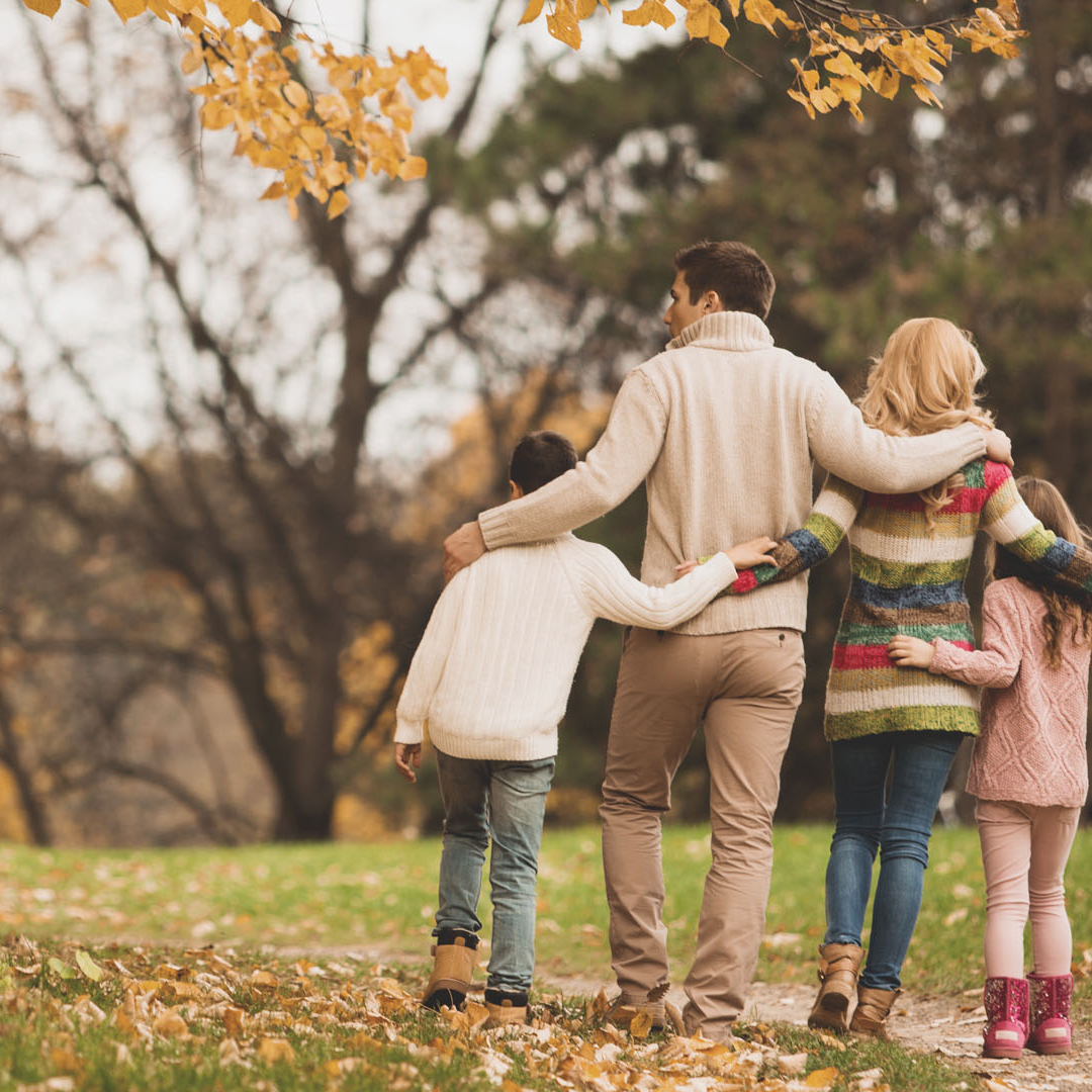 Eine Familie spaziert an einem Herbsttag.
