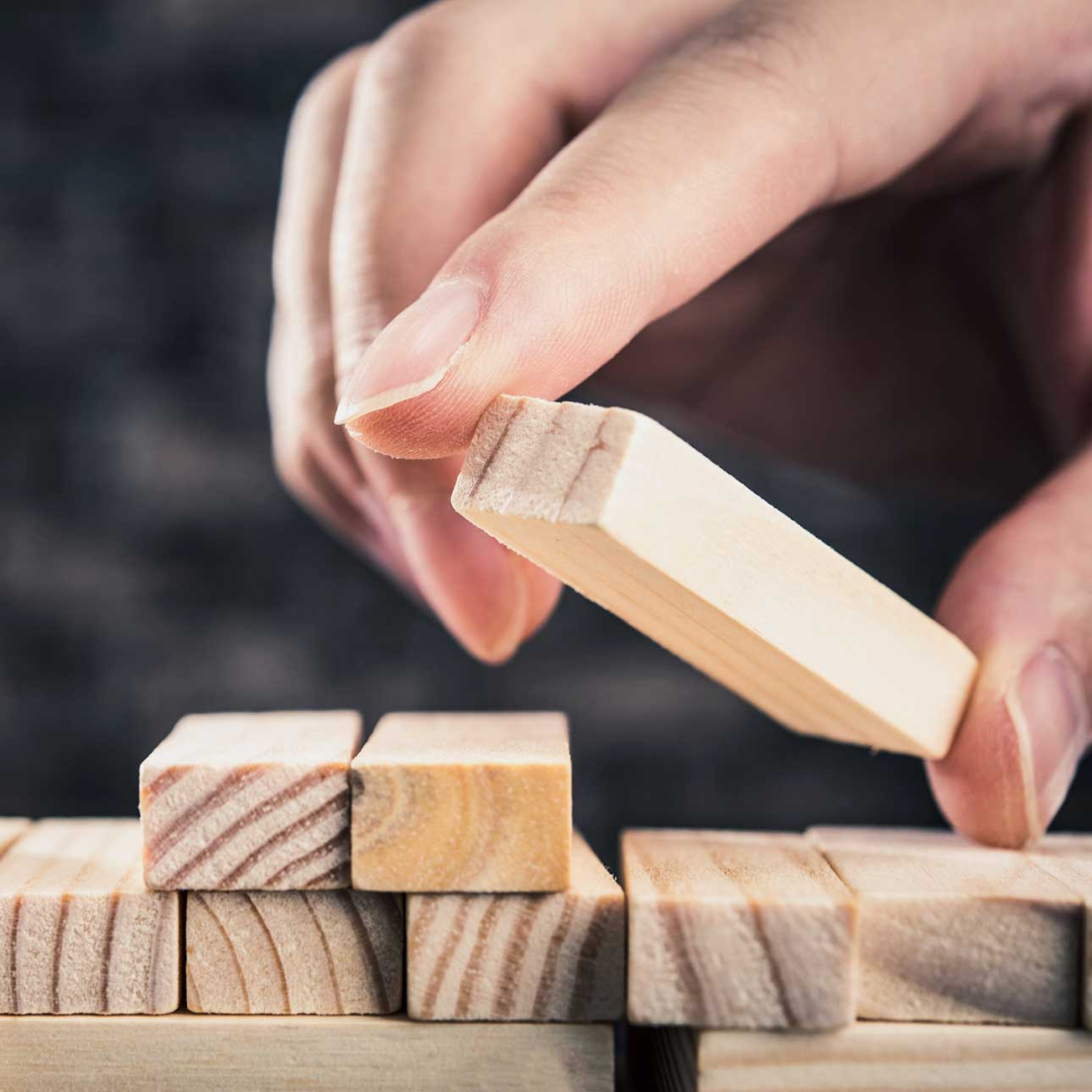 A woman puts a small piece of wood on a stack with small wood pieces