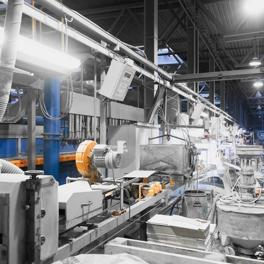 Produktionshalle mit Maschinen im Vordergrund und Personen im Hintergrund