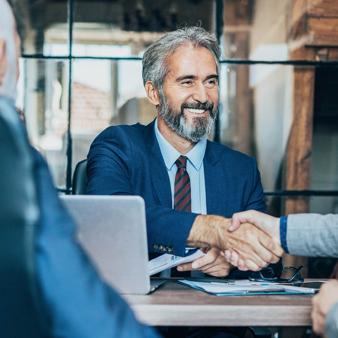 Businessmann schüttelt einer anderen Person die Hand