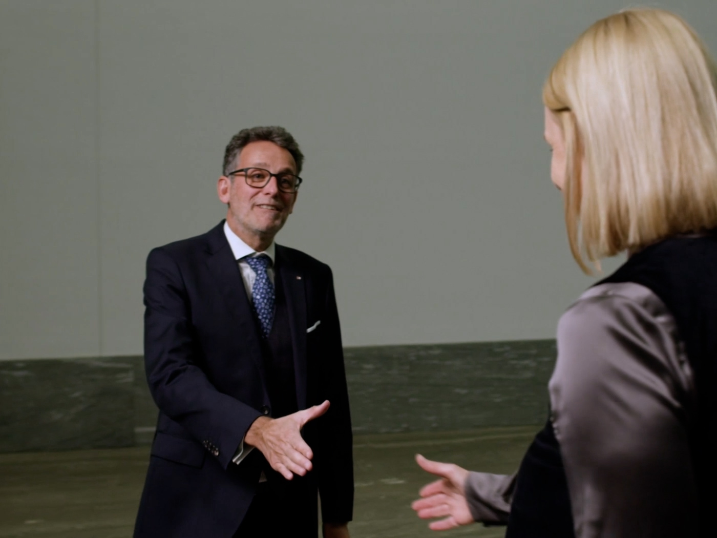 Gerhard Burtscher begrüßt eine Kundin von der BTV Vier Länder Bank in Innsbruck