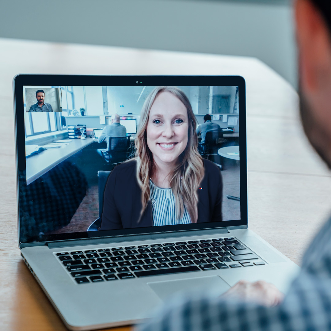 A man communicates via video call on the laptop with a female employee