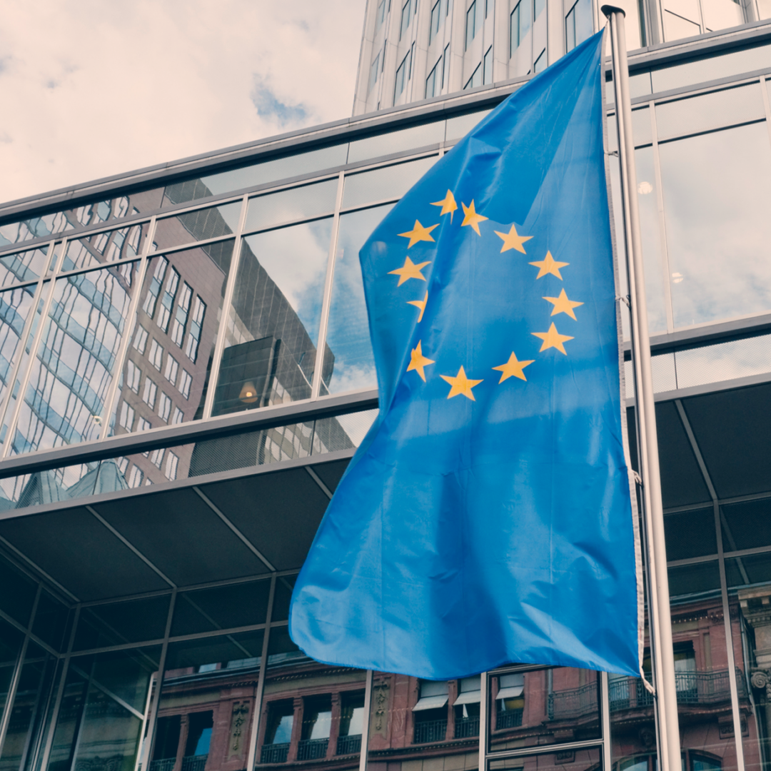 Außenansicht der Europäischen Zentralbank mit der Flagge der EU im Vordergrund