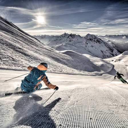 2 Skifahrer bei Sonnenaufgang, unverspurte Piste
