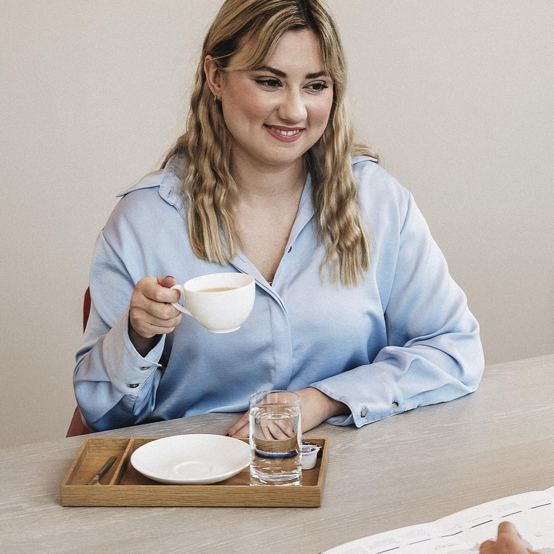 Ein Frau mit einer Tasse Kaffee spricht mit einem Mann.