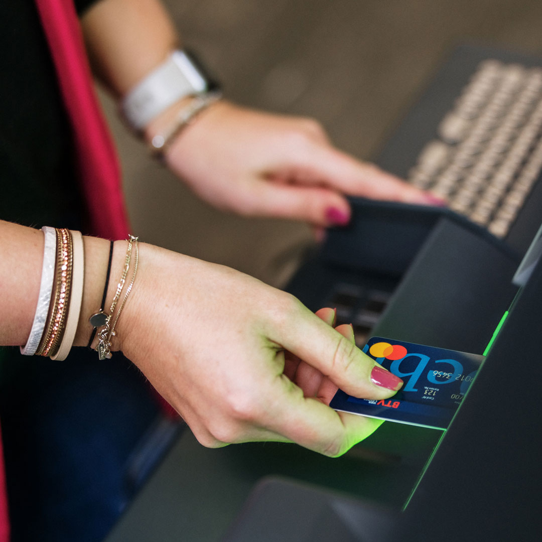 Eine Frau steckt eine Debitkarte in einen Geldautomaten.