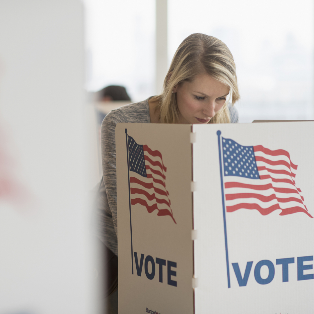 Frau steht bei Kabine bei der US-Wahl.