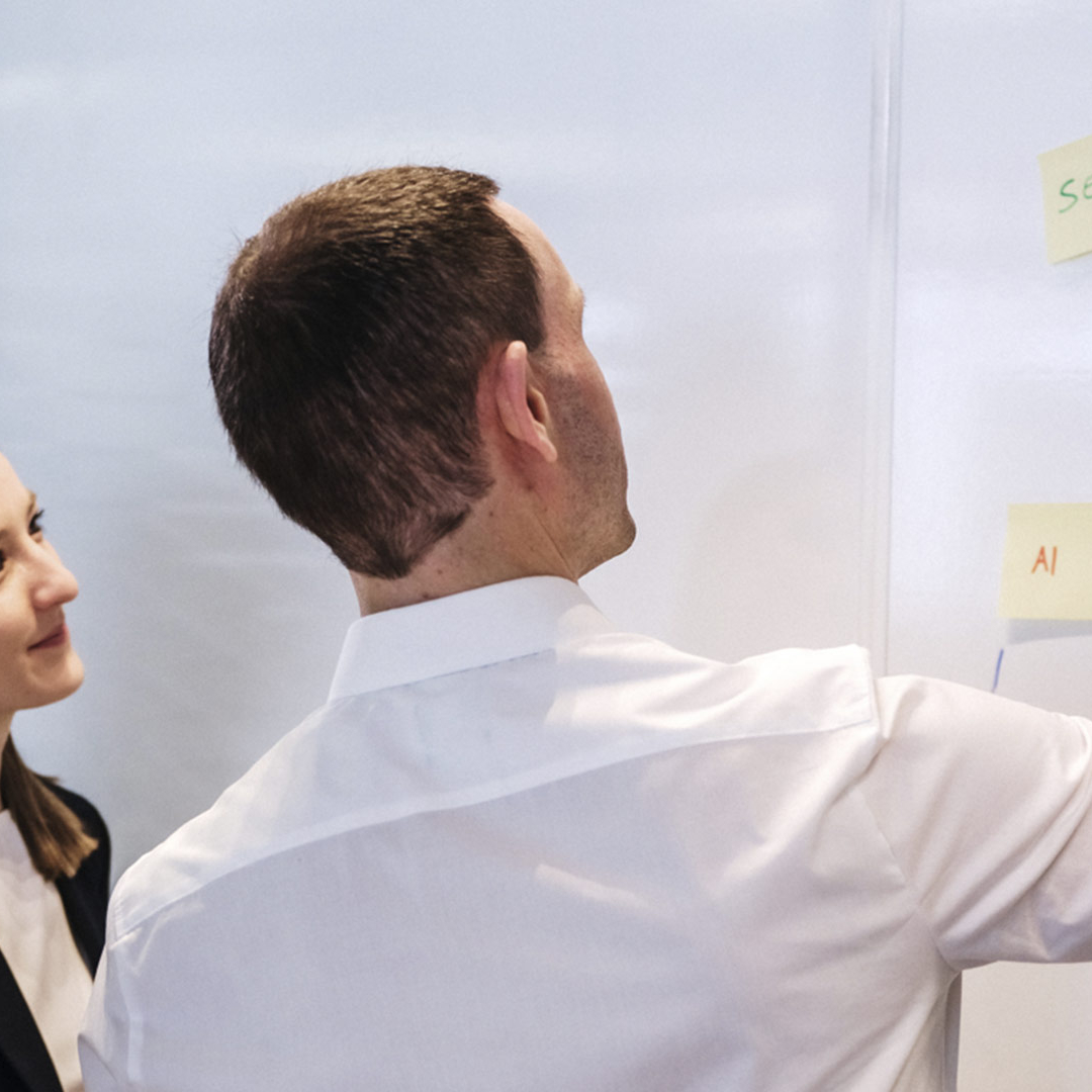 Eine Person zeigt etwas auf einem Whiteboard.