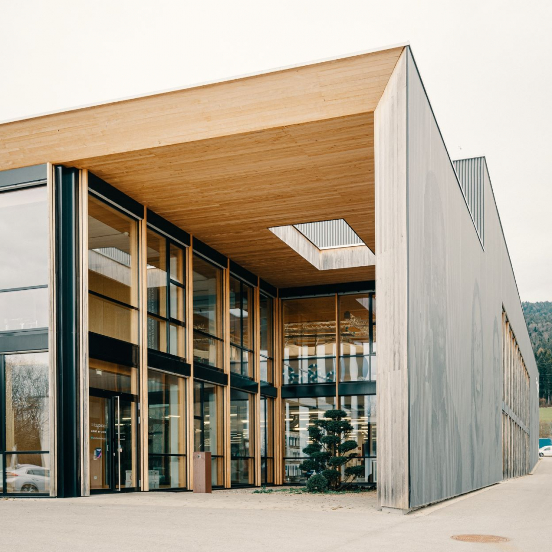 Außenaufnahme vom Typico Firmensitz: Holzbau mit vielen Fenstern und Dachfenster